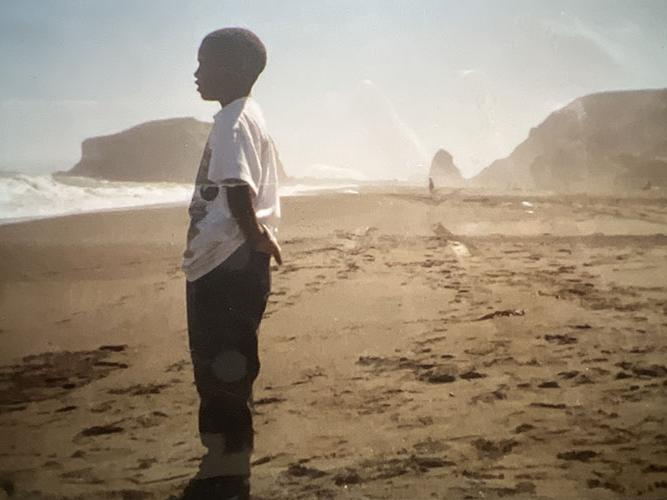 Boy at the beach looking at the water